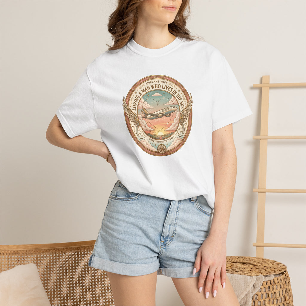 Person wearing a white t-shirt with a graphic design and denim shorts in a casual setting.