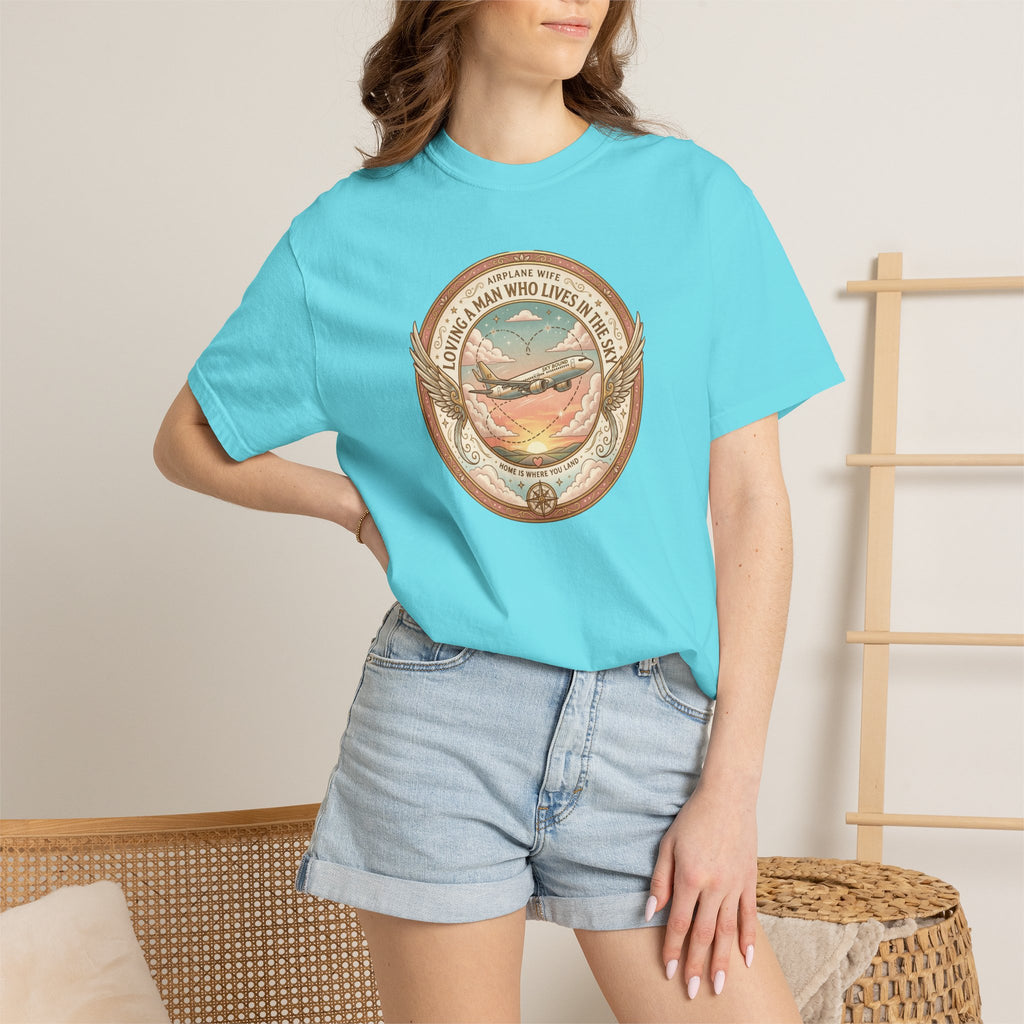 Person wearing a light blue t-shirt with a graphic design, standing against a neutral background.