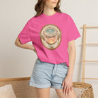 Person wearing a pink t-shirt with a graphic design, standing against a neutral background.