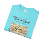 Folded light blue t-shirt with airplane graphic and text on a white background
