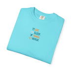 Folded light blue t-shirt with travel-themed text on a white background