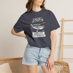 Person wearing a navy blue t-shirt with a graphic design and text, standing against a neutral background.