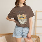 Person wearing a brown t-shirt with a graphic design and text, standing against a neutral background.