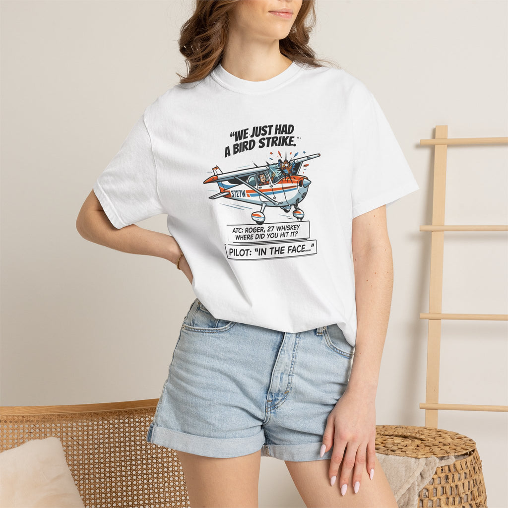 Person wearing a white t-shirt with a graphic design and text, standing against a neutral background.