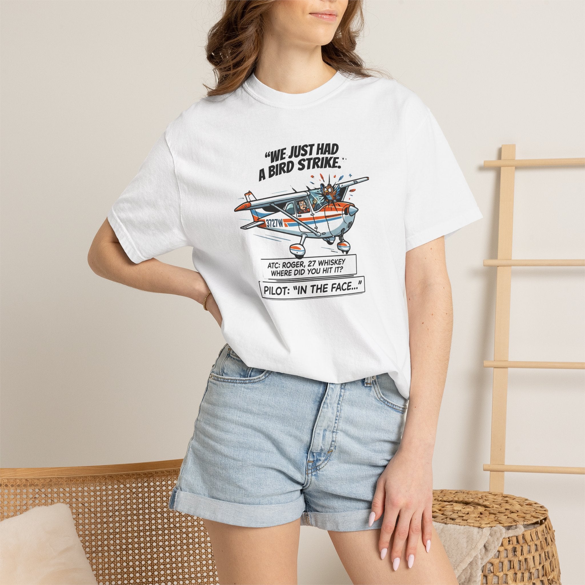 Person wearing a white t-shirt with a graphic design and text, standing against a neutral background.