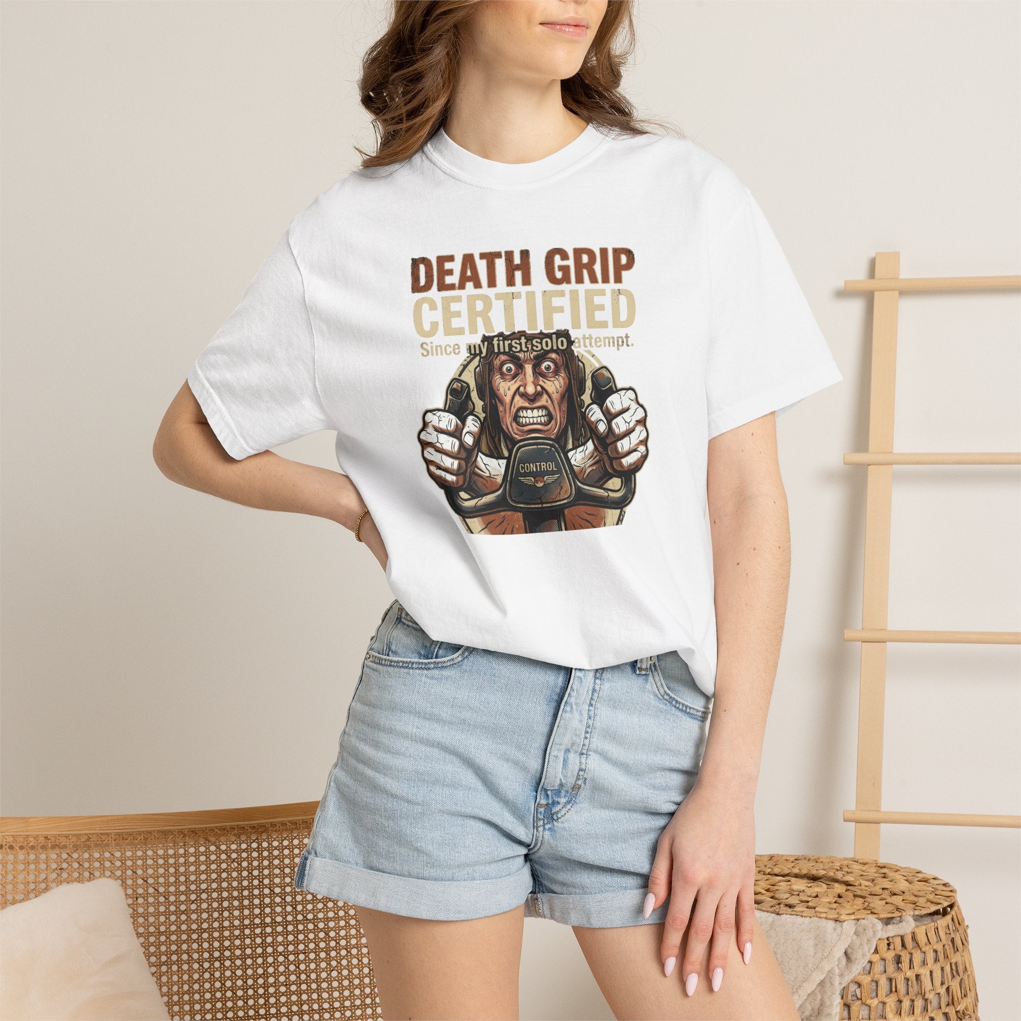 attractive woman wearing a white t-shirt with a graphic design and text, standing against a neutral home background.