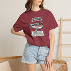 Person wearing a maroon t-shirt with a graphic design and text, standing against a neutral background.